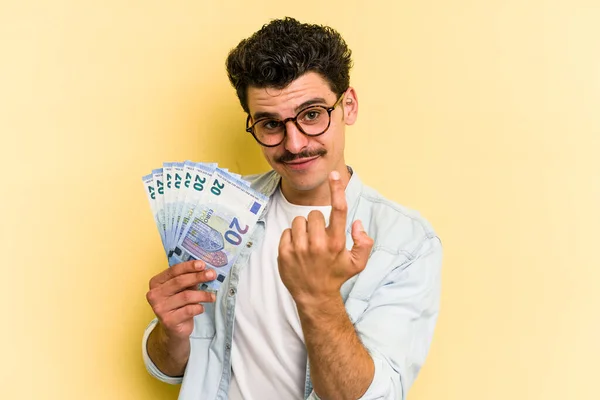 Young Caucasian Man Holding Banknotes Isolated Yellow Background Pointing Finger — Stockfoto
