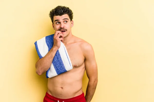 Young Caucasian Man Holding Beach Towel Isolated Yellow Background Relaxed — Photo