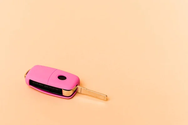 ベージュの背景に隔離されたピンクの車のキー — ストック写真