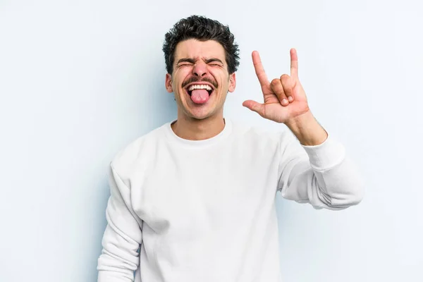 Jovem Caucasiano Isolado Fundo Azul Mostrando Gesto Rocha Com Dedos — Fotografia de Stock