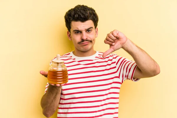 Young Caucasian Man Holding Honey Jar Isolated Yellow Background Showing — ストック写真