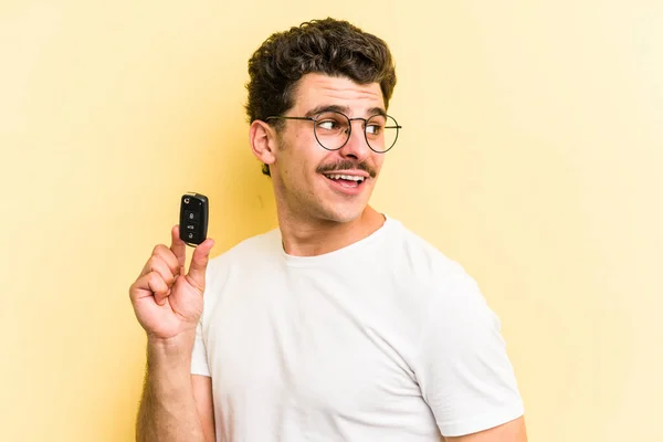 Young Caucasian Man Holding Car Keys Isolated Yellow Background Looks — Foto Stock