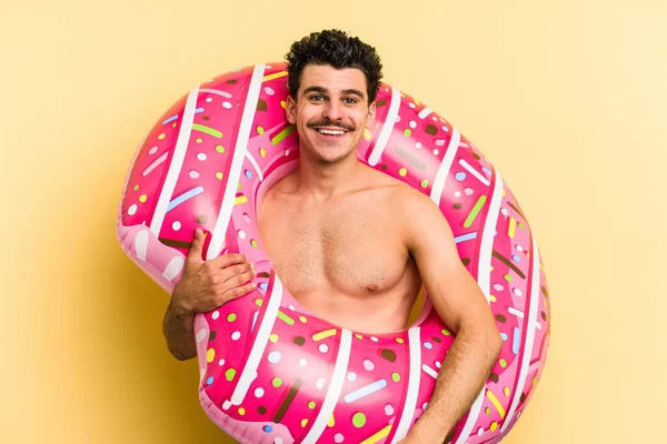 Young Caucasian Man Holding Inflatable Donut Isolated Yellow Background Happy — Stock Fotó