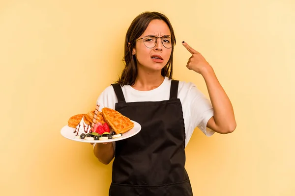 Mujer Joven Hispana Dependiente Sosteniendo Gofres Aislados Sobre Fondo Amarillo — Foto de Stock