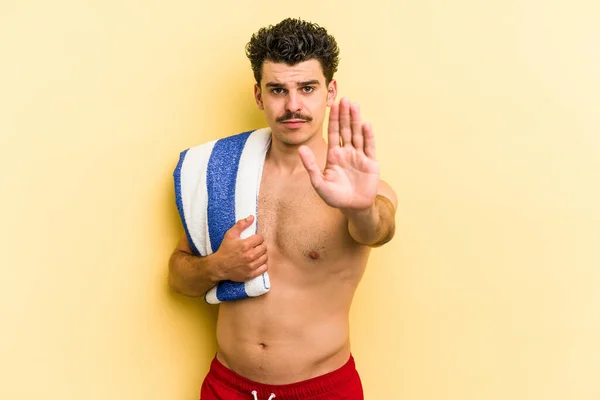 Young Caucasian Man Holding Beach Towel Isolated Yellow Background Standing — Photo