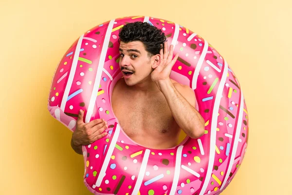 Young Caucasian Man Holding Inflatable Donut Isolated Yellow Background Trying — Stock fotografie