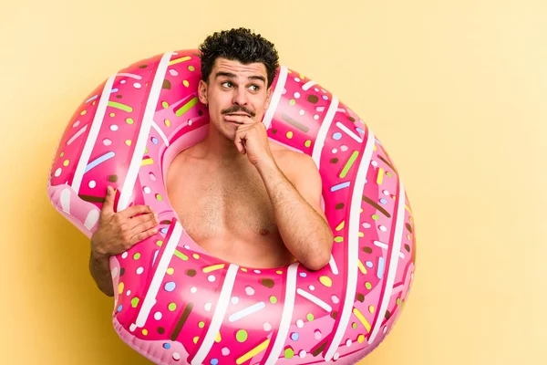 Young Caucasian Man Holding Inflatable Donut Isolated Yellow Background Relaxed — 图库照片