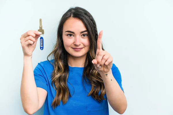 Young Caucasian Woman Holding Home Keys Isolated Blue Background Showing — Stok fotoğraf