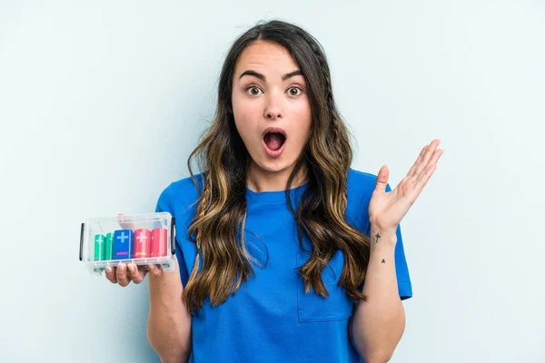 Young Caucasian Woman Holding Batteries Isolated Blue Background Surprised Shocked — Stock fotografie