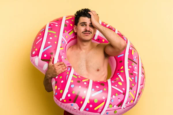 Young Caucasian Man Holding Inflatable Donut Isolated Yellow Background Being — Stock Fotó