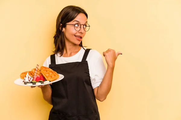 Jovem Hispânica Dependente Mulher Segurando Waffles Isolado Pontos Fundo Amarelo — Fotografia de Stock