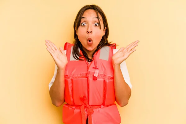 Young Hispanic Woman Holding Life Jacket Isolated Yellow Background Surprised — Stock Photo, Image