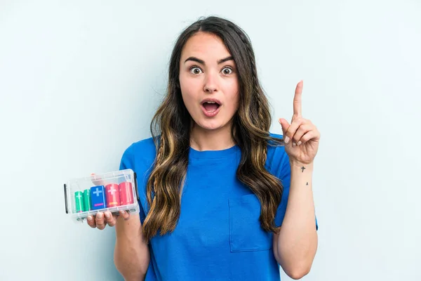 Young Caucasian Woman Holding Batteries Isolated Blue Background Having Some — Stock fotografie