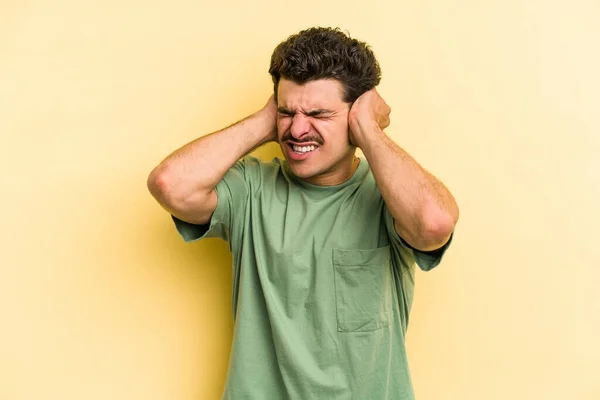 Jeune Homme Caucasien Isolé Sur Fond Jaune Couvrant Les Oreilles — Photo