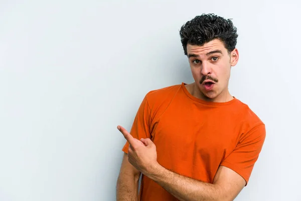 Joven Hombre Caucásico Aislado Sobre Fondo Azul Sonriendo Señalando Lado —  Fotos de Stock