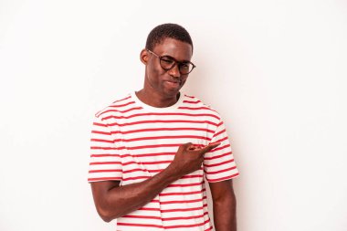 Beyaz arka planda izole edilmiş genç Afrikalı Amerikalı adam gülümsüyor ve boş alanda bir şeyler gösteriyor..