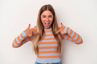 Beyaz arka planda izole edilmiş genç Rus kadın parmağını göstererek şaşırdı, geniş bir gülümsemeyle..