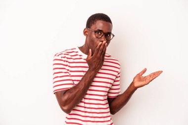 Beyaz arka planda izole edilmiş genç Afro-Amerikalı adam, avuç içi fotokopi alanı tutmaktan etkilenmiş..