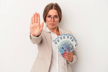 Elinde banknotlar tutan genç Rus iş kadını beyaz arka planda elini uzatmış, dur işaretini gösteriyor ve seni engelliyor..