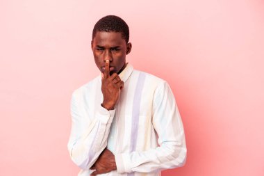 Genç Afrikalı Amerikalı bir adam pembe arka planda izole edilmiş düşünüyor ve yukarı bakıyor, yansıtıyor, düşünüyor, hayal kuruyor..