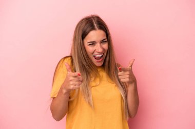 Pembe arka planda izole edilmiş genç Rus kadın gülüyor ve gözlerini kapatıyor, rahatlamış ve mutlu hissediyor..