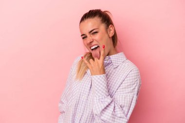 Pembe arka planda izole edilmiş genç bir Rus kadın. Baş parmağını kaldırıyor. Zor bir seçim.