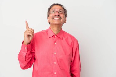 Middle aged indian man isolated on white background indicates with both fore fingers up showing a blank space.