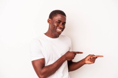 Beyaz arka planda izole edilmiş genç Afro-Amerikalı adam işaret parmağıyla işaret ettiği için heyecanlı..