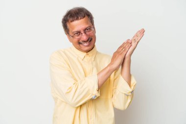 Middle aged indian man isolated on white background feeling energetic and comfortable, rubbing hands confident.