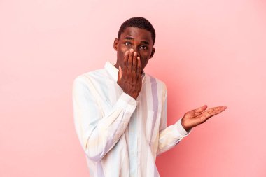 Pembe arka planda izole edilmiş genç Afro-Amerikan bir adam..