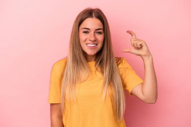 Pembe arka planda izole edilmiş genç Rus kadın hoş bir sürprizle karşılaşıyor, heyecanlı ve el kaldırıyor..