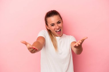 Pembe arka planda izole edilmiş genç Rus kadın kameraya sarıldığı için kendinden emin hissediyor..