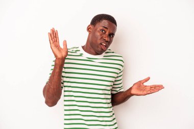 Beyaz arka planda izole edilmiş genç Afrikalı Amerikalı bir fotokopi çekmek için kafası karışık ve omuz silkiyor..