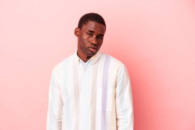 Genç Afrikalı Amerikalı bir adam pembe arka planda izole edilmiş üzgün, ciddi yüzlü, mutsuz ve hoşnutsuz..
