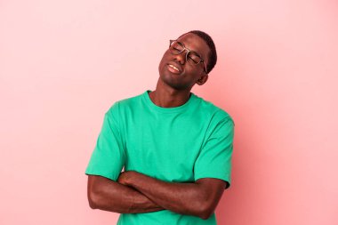 Genç Afrikalı Amerikalı bir adam pembe arka planda izole edilmiş hedeflerine ve amaçlarına ulaşma hayali kuruyor.