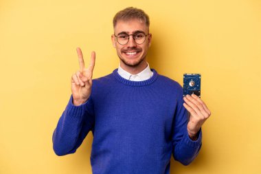 Young computer man isolated on yellow background showing number two with fingers.