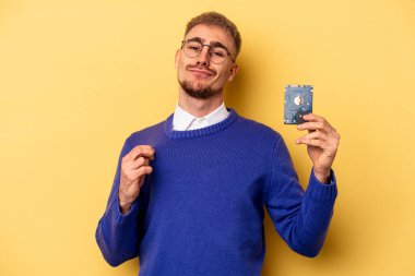 Young computer man isolated on yellow background