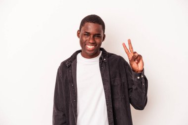 Genç Afrikalı Amerikalı adam beyaz arka planda izole edilmiş neşeli ve kaygısız parmaklarıyla barış sembolü gösteriyor..