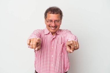Middle aged indian man isolated on white background cheerful smiles pointing to front.