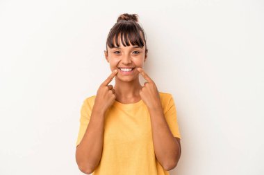 Beyaz arka planda izole edilmiş genç bir ırk kadını gülümsüyor, parmaklarını ağzına doğrultuyor..