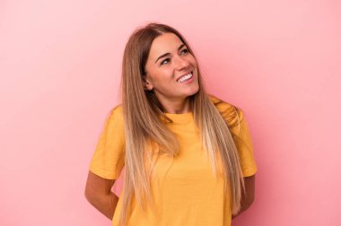 Pembe arka planda izole edilmiş genç Rus kadın gülümsüyor ve başparmağını kaldırıyor.