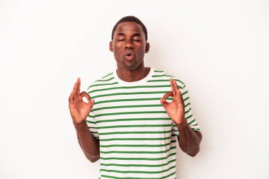 Genç Afrikalı Amerikalı erkek, beyaz arka planda izole edilmiş yoğun bir günün ardından dinleniyor, yoga yapıyor..