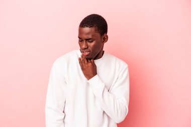Pembe arka planda izole edilmiş genç Afrikalı Amerikalı bir adam virüs ya da enfeksiyon yüzünden boğazında acı çekiyor..
