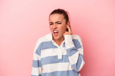 Pembe arka planda izole edilmiş genç Rus kadın parmaklarıyla ön tarafı işaret ediyor..