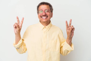 Middle aged indian man isolated on white background showing victory sign and smiling broadly.