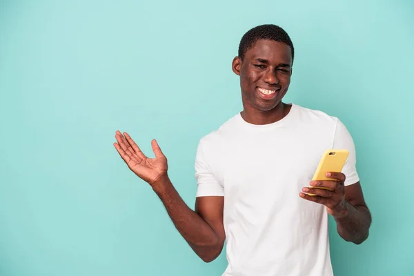 Young African American Man Holding Mobile Phone Isolated Blue Background — Stock Photo, Image