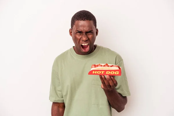 Młody Afroamerykanin Zjada Hot Doga Białym Tle Krzycząc Bardzo Wściekły — Zdjęcie stockowe