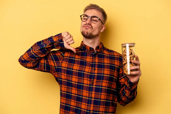 Young Caucasian Man Holding Cookies Jar Isolated Yellow Background Feels — Stock fotografie
