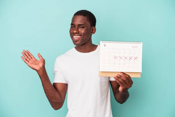 Jonge Afro Amerikaanse Man Met Een Kalender Geïsoleerd Blauwe Achtergrond — Stockfoto