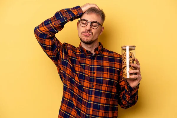 Young Caucasian Man Holding Cookies Jar Isolated Yellow Background Being — Foto Stock